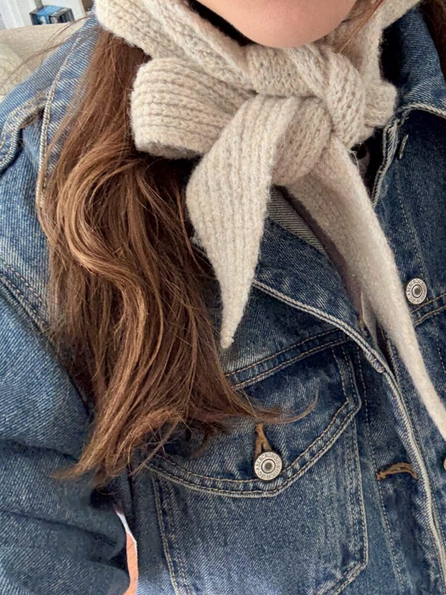 a woman wears a knit bonnet over a denim jacket