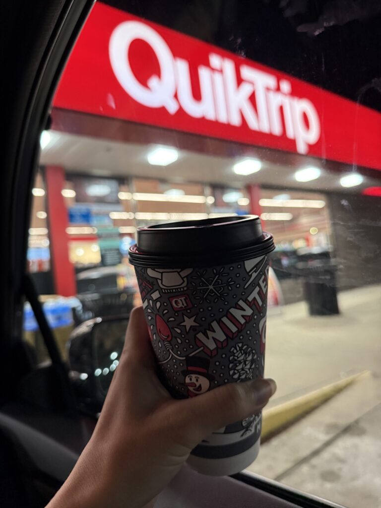 a hot cocoa cup being held outside of quiktrip